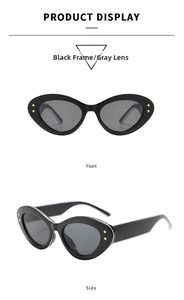 Detail of oval cat eye sunglasses with black frames, gray lenses and gold star accents