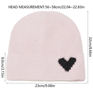 Pink knitted beanie with black heart patch showing size measurements 56-58cm for winter