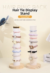 Detail of white velvet scrunchie holders with wooden bases and gold metal accents