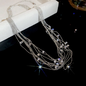 Close-up of silver multi-layer fringe necklace with sparkling crystals on black display