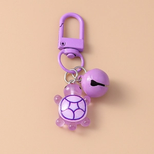 Detail of purple resin turtle charm with matching metal bell for backpack or keys