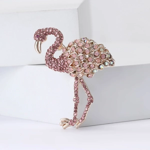 Exquisite gold flamingo brooch with pink crystals and rhinestones on a white background