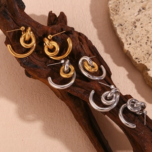 18K gold plated stainless steel layered lock hoop earrings on a rustic wood stand