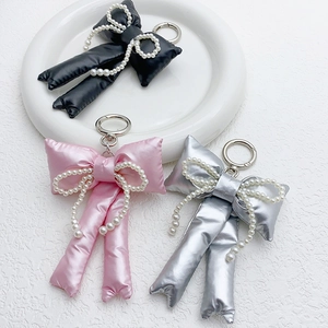 Handmade glossy fabric bow keychains with pearls in black, pink, and silver colors
