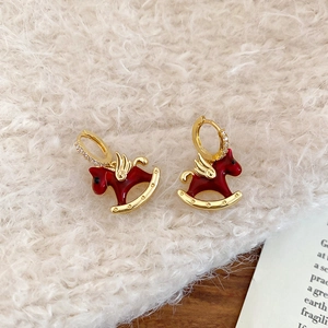 Détail de boucles d'oreilles cheval à bascule en émail rouge et zircons dorés