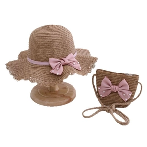 Kids straw sun hat and matching bag set with pink bows and pearls on white background