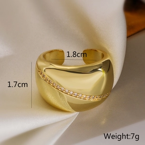 Détail d'une bague géométrique dorée avec zircons incrustés et profil de 1,7 cm