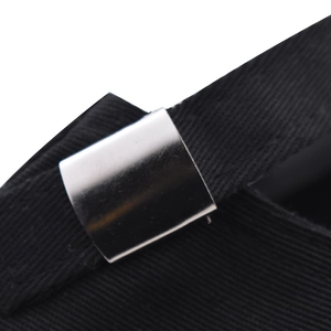 Detailed macro view of the silver metal adjustable buckle on a black twill baseball cap