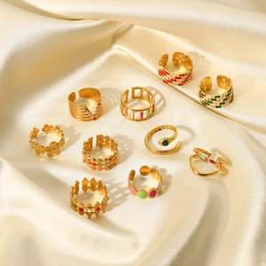 Detail of 10-piece 18K gold plated rings with colorful enamel on silk background
