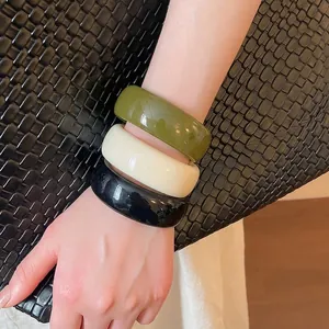 Lot de trois bracelets larges en résine acrylique noire, crème et vert olive