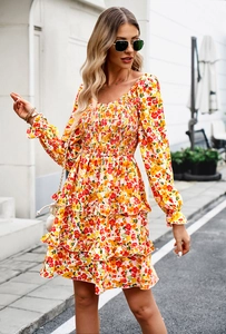 Detail of floral mini dress featuring tiered ruffle hem and long sleeves in outdoor setting