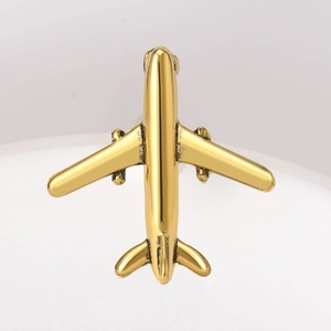 Macro shot of minimalist gold airplane lapel pin with a sleek polished finish