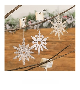 Hanging snowflake ornaments in gold, white and glitter on festive branches