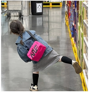 Détail de la sacoche enfant rose néon avec logo NTE noir et bandoulière ajustable