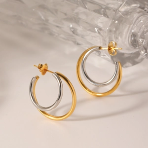 Detail of minimalist double-layered stainless steel hoop earrings with gold and silver finish