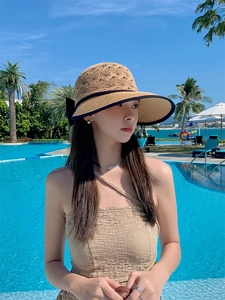 Detail of hollow-out straw hat texture with black ribbon bow and wide brim design