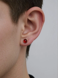 Close-up of model wearing gold-framed round red jasper stud earring in S925 silver