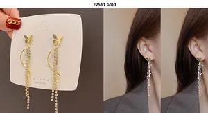 Detailed view of gold butterfly tassel earrings with zircon chains on model and card
