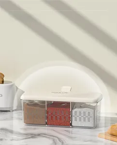 Detailed view of the three-compartment transparent spice box with a white airtight lid