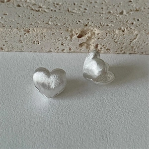 Minimalist matte silver heart stud earrings with brushed texture on natural stone base