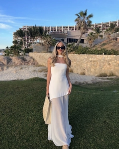Detail of white strapless maxi dress with asymmetrical hem and matching choker scarf