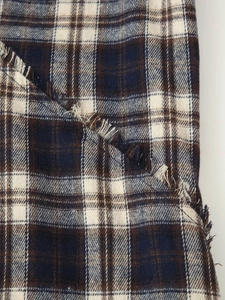 Macro detail of plaid fabric texture with frayed hem design on a sleeveless long dress