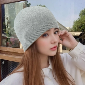 Close-up of light gray ribbed knit beanie showing soft wool blend texture on a model