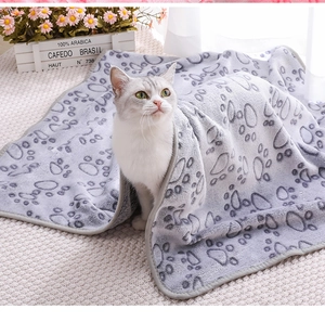 Close-up of soft flannel pet blanket with grey paw print pattern and cute cat detail