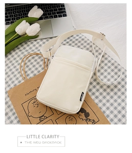 Close-up of cream corduroy small crossbody bag with adjustable strap and sport tag