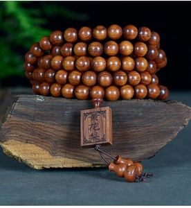 Vue macro de 108 perles de prière en bois de poirier jaune avec plaque gravée sur bois