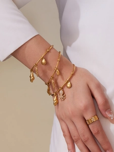 Golden sea shell and octopus charms on adjustable bangles with a star ring