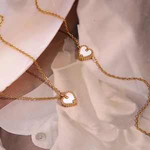 Détail du collier en acier plaqué or 18K avec pendentifs en forme de cœur en nacre