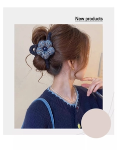 Détail d'une pince à cheveux fleur tricotée portée en demi-queue pour un look vintage