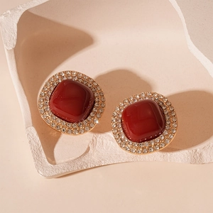 Détail de boucles d'oreilles vintage avec pierre rouge carrée et cristaux brillants