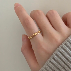Detailed view of the gold heart and infinity symbol interlocking ring design