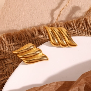 Detailed macro view of 18K gold plated stainless steel triple-layer wing stud earrings