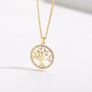 Close-up of gold tree of life pendant featuring white and pink zircon stone accents