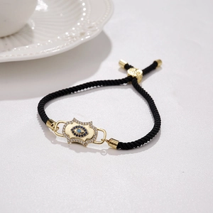 Close-up of adjustable Milan rope bracelet featuring a gold-plated zircon evil eye charm