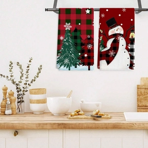 Christmas kitchen towels with buffalo plaid tree and snowman designs hanging in a cozy kitchen