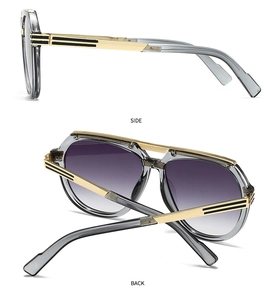 Detail view of modern retro sunglasses with gold-black frame and purple gradient lenses