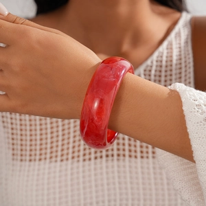 Detail of red marble texture resin bangle on model with white mesh clothing