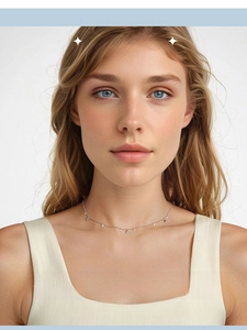 Detail view of a dainty S925 sterling silver star fringe necklace worn by a professional model