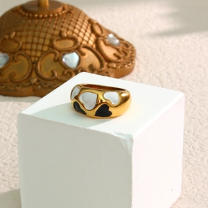 18k gold plated wide ring with black and white enamel heart patterns on white stand