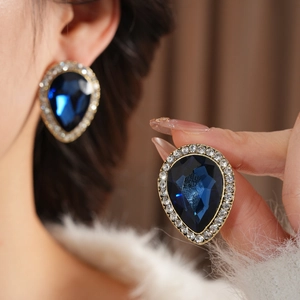 Détail de la boucle d'oreille goutte avec pierre bleue foncée et strass brillants