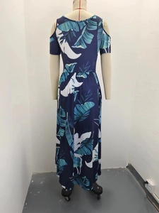 Detail view of the deep blue tropical leaf print and off-shoulder design on a summer dress