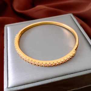 Detailed macro view of a 24K gold-plated hinged bangle with pavé-set sparkling zircons