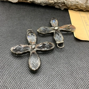 Pendentif croix rétro plaqué argent avec verre cristal sur fond texturé vintage