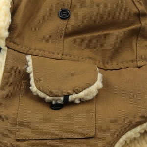 Détail de la veste en toile marron avec doublure en molleton et poche à couture renforcée