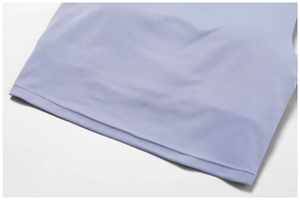 Close-up of double-needle stitching on the hem of a matte lavender yoga tank top