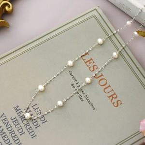 Detail of freshwater pearl necklace on a vintage notebook with soft aesthetic lighting